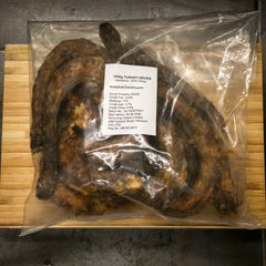 Packaged turkey necks with a label on a wooden surface