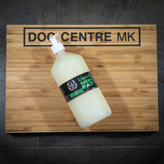 A bottle of sheep fat on a wooden board with 'DOG CENTRE MK' printed on it.