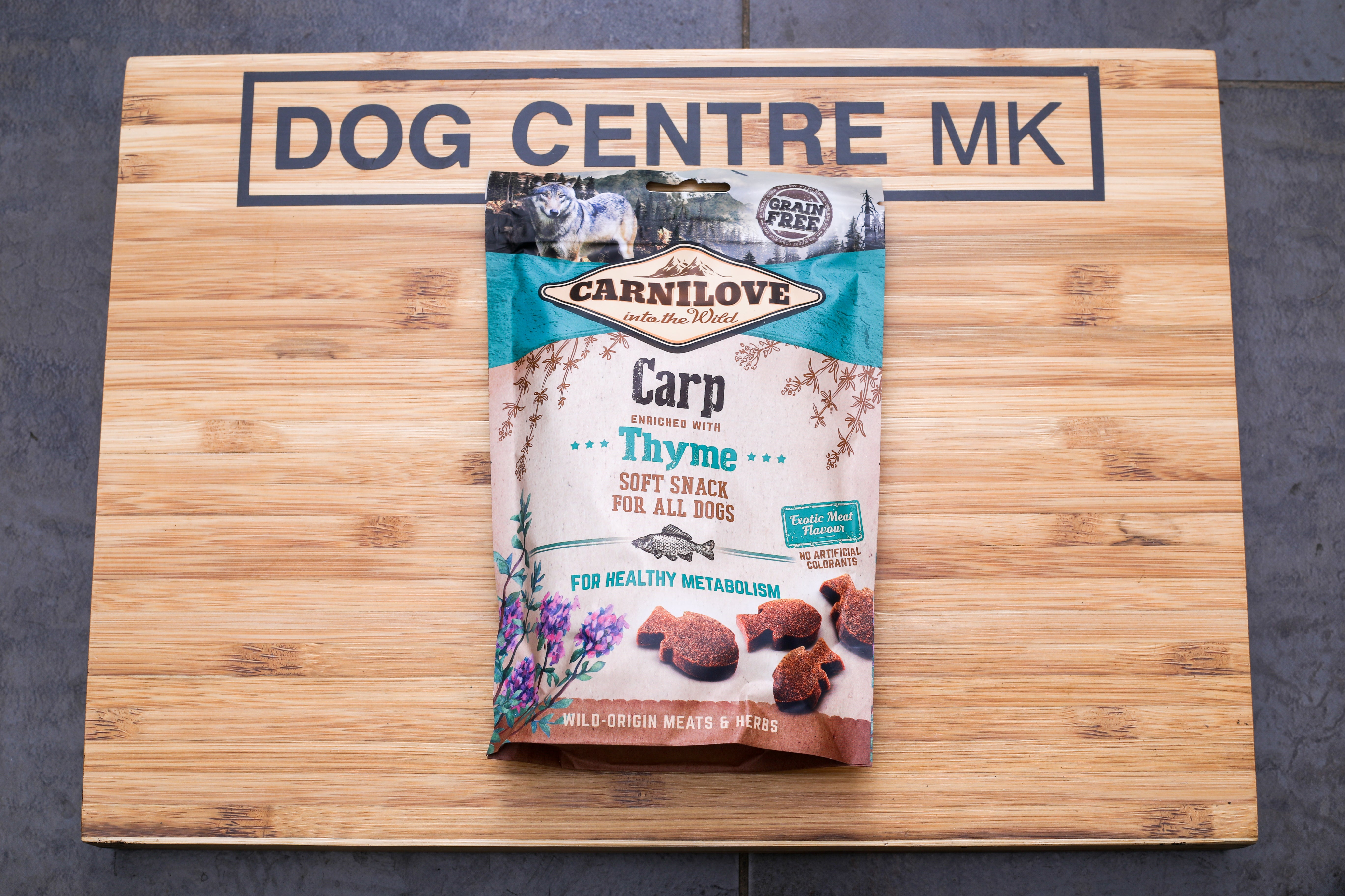 Carp enriched with thyme soft snack for dogs packaging on a dog centre mk branded wooden board