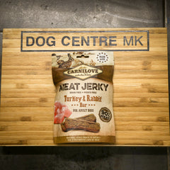 CarniLove Meat Jerky package on a wooden board with 'Dog Centre MK' branding.