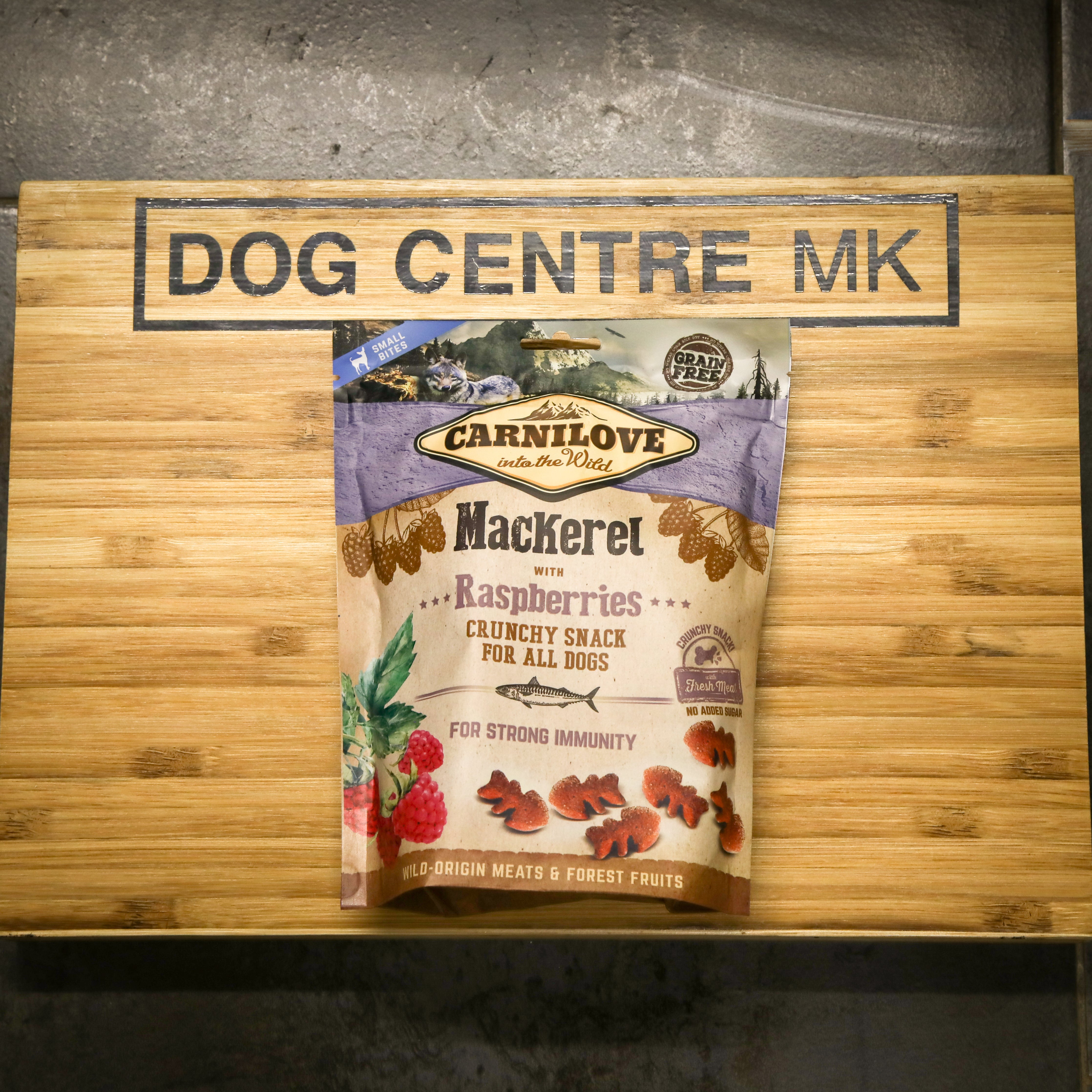 Carnilove dog food package on a wooden board with 'Dog Centre MK' branding.