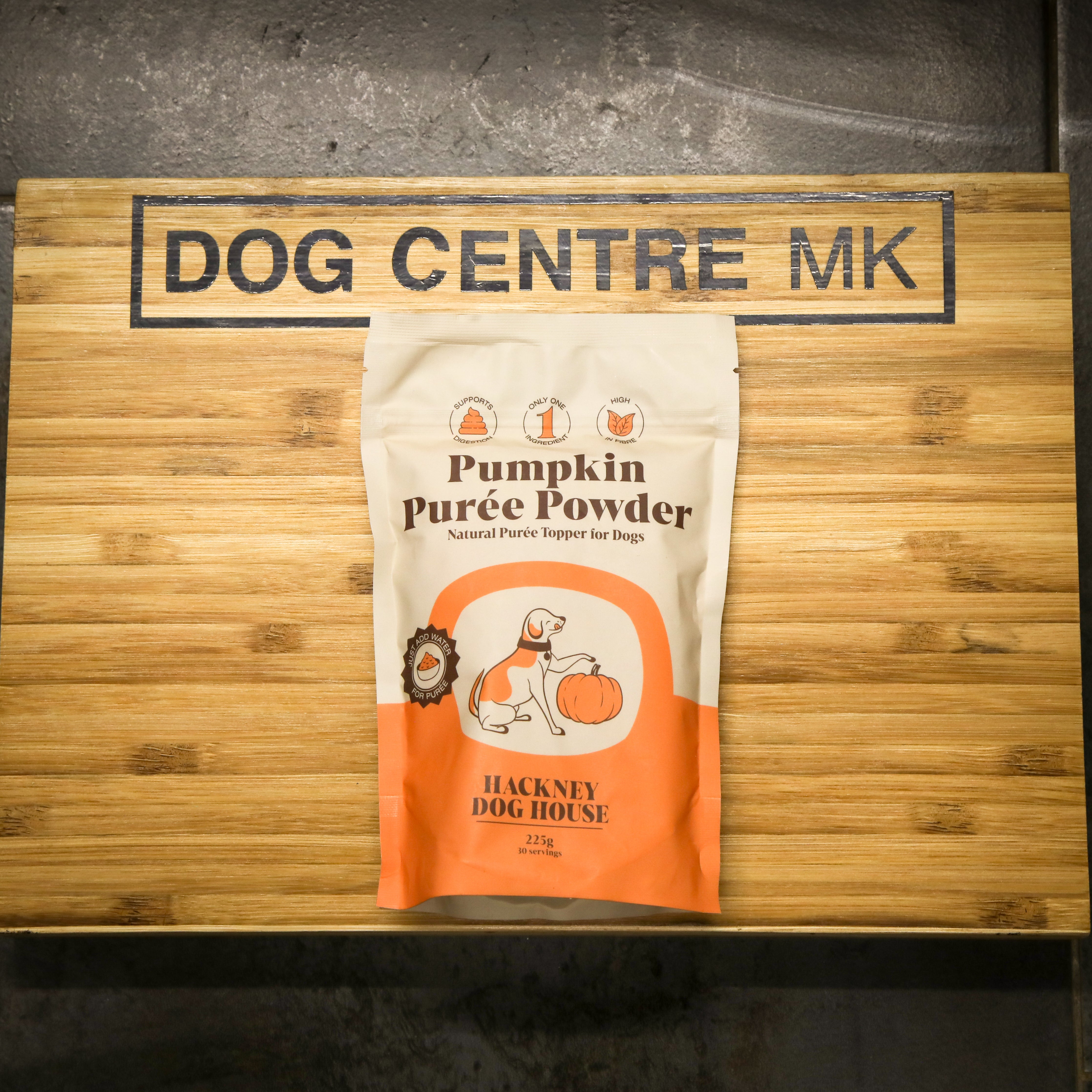 Package of Hackney Dog House Pumpkin Puree Powder on a wooden board with 'Dog Centre MK' branding.