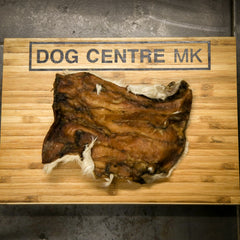 Hairy beef skinskin on a wooden board with 'DOG CENTRE MK' branding.