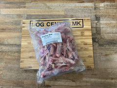 frozen duck feet in a bag on dog centre mk branded wooden board
