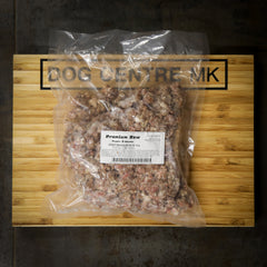 Package of premium raw goat mince on a wooden board with 'Dog Centre MK' branding.