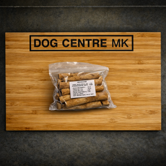 Packaged dog treats on a wooden board with 'DOG CENTRE MK' branding.